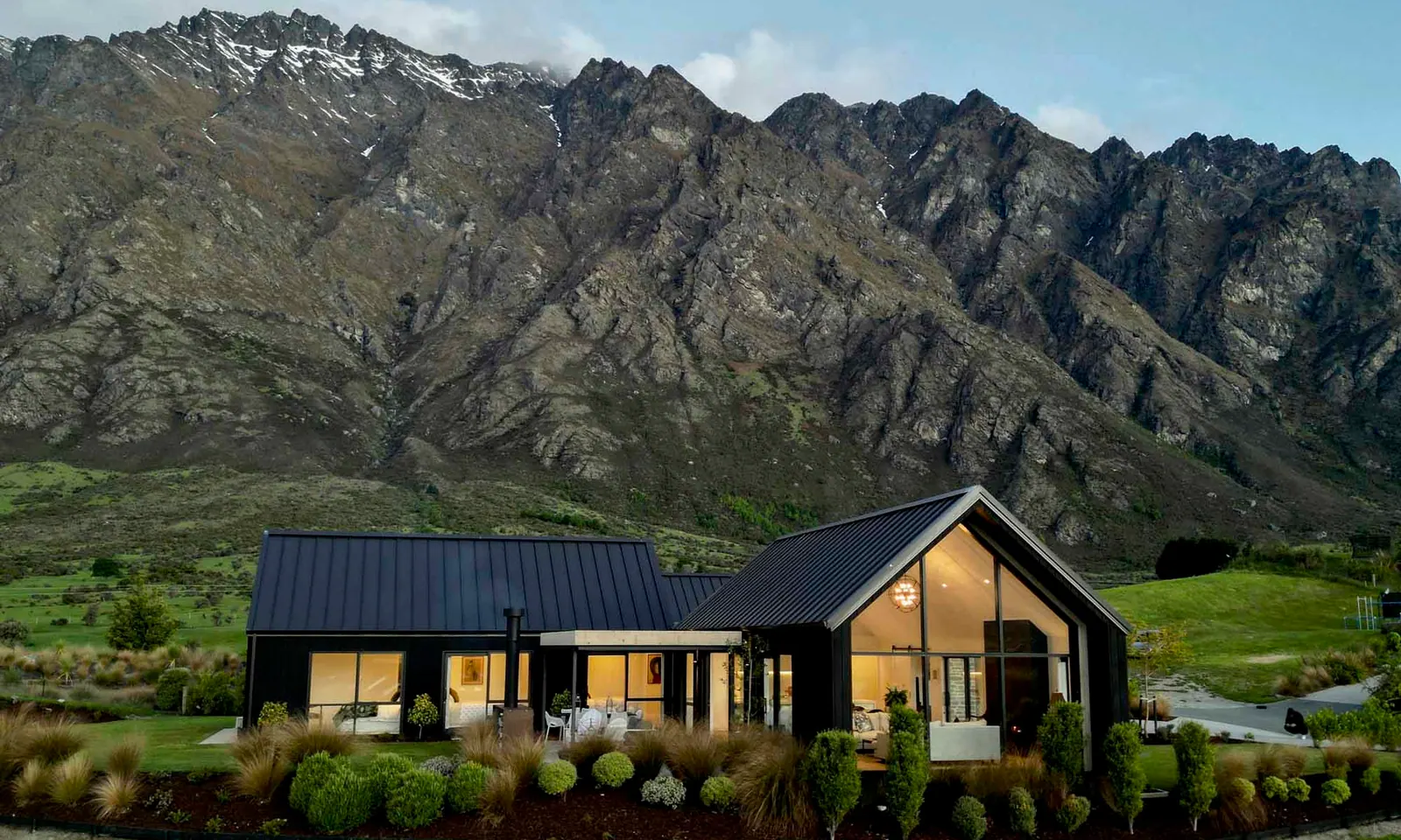 Casa contemporánea con grandes ventanales frente a la montaña